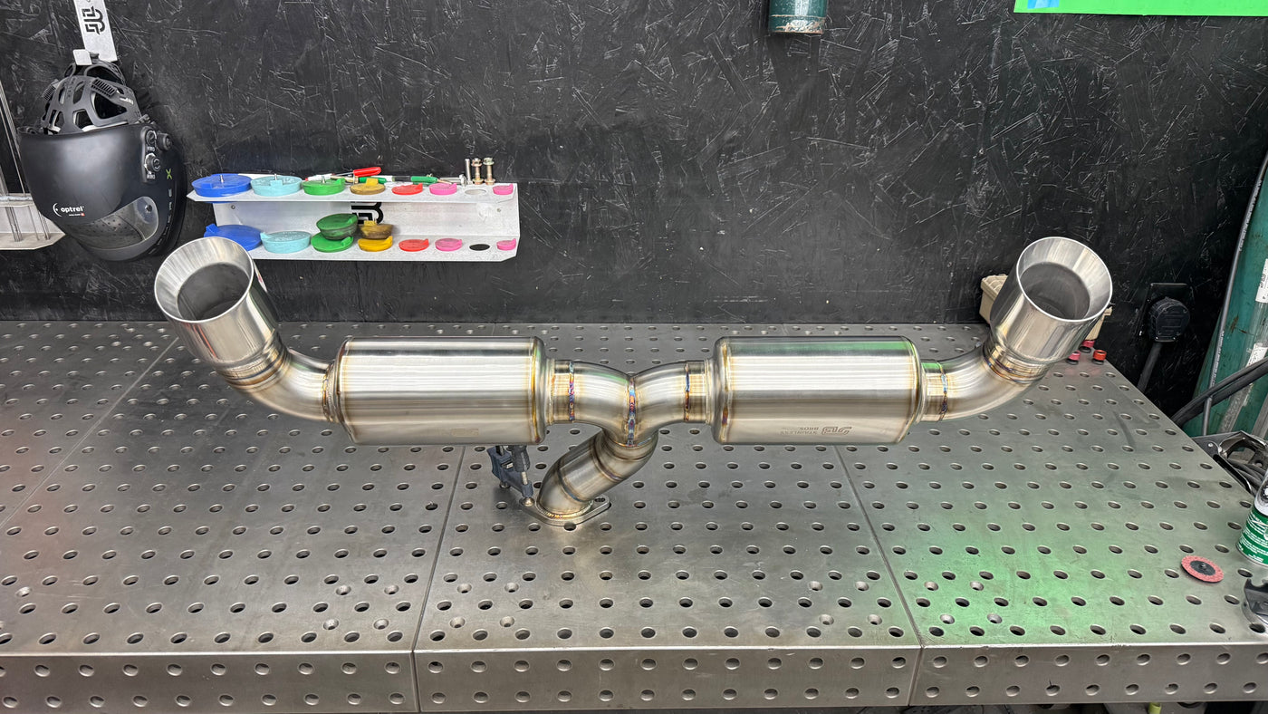 Brockett Built BRZ GR86 dual-exit axle-back exhaust with Jones slant-cut tips, 304 stainless, on the weld table