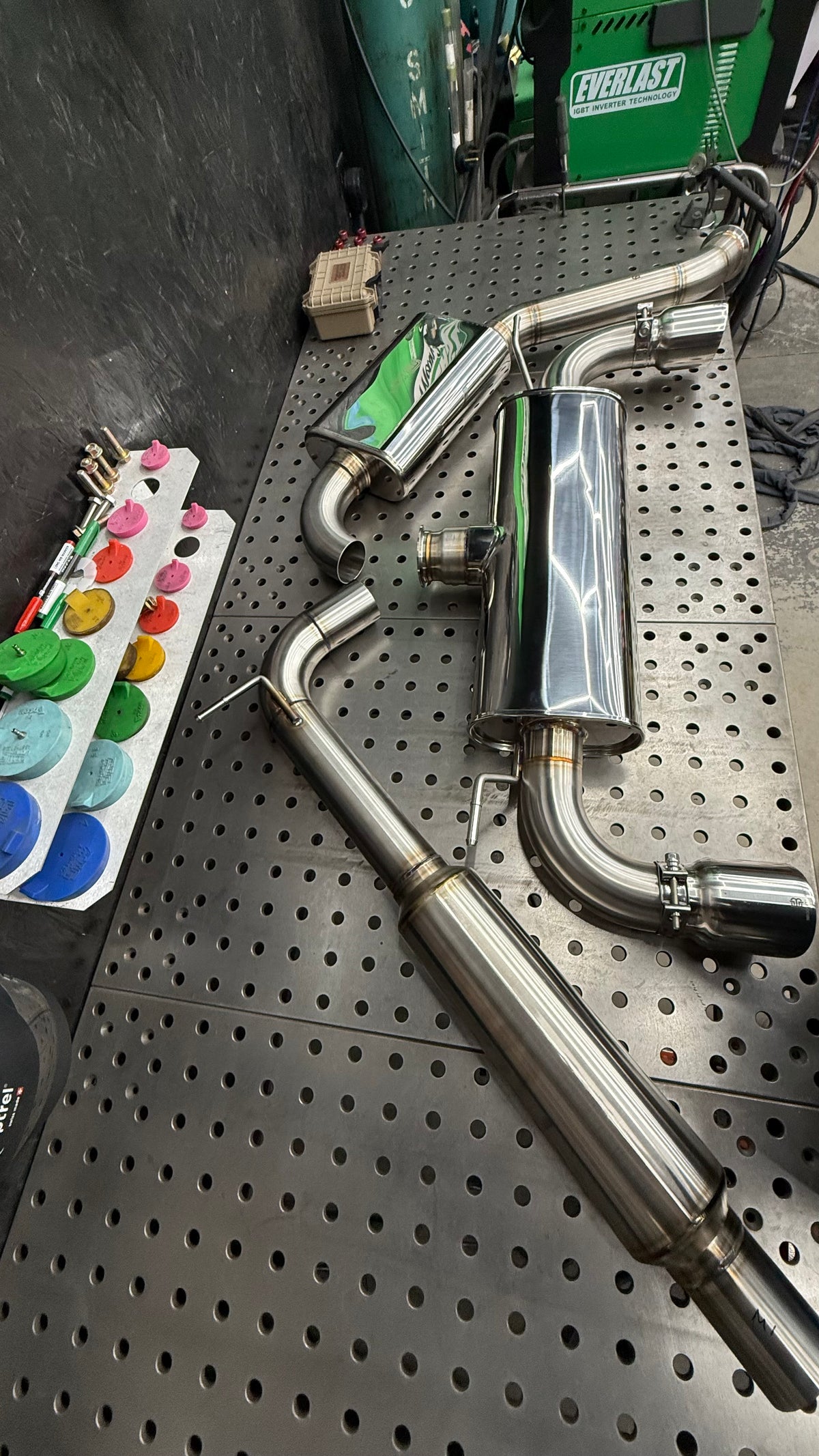 Mk7 GTI Stealth cat-back exhaust sections on the welding table, resonated mid-pipe, oval muffler and rear muffler